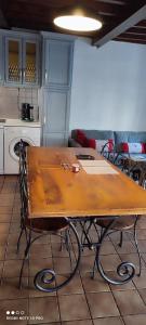 eine Küche mit einem Holztisch mit Stühlen in der Unterkunft LA RUSTIQUE DU BOUT DU LAC in Chambon-sur-Lac