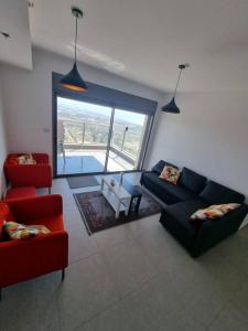ein Wohnzimmer mit 2 Sofas und einem Tisch in der Unterkunft דירת גג ים עכו חיפה נוף מרהיב in Akkon