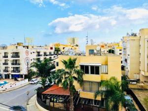 a view of a city with palm trees and buildings at Mackenzie apartment 301 in Larnaca