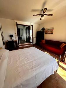 a bedroom with a large white bed and a couch at La Mansarda di Anastasia in Monteroni di Lecce