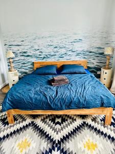 - un lit avec couette bleue dans une chambre avec eau dans l'établissement Blaue Butze, à Kronshagen