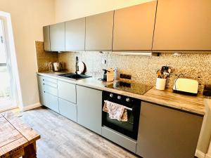 cocina con electrodomésticos de acero inoxidable y suelo de madera en Blaue Butze en Kronshagen