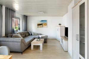 ein Wohnzimmer mit einem Sofa und einem Tisch in der Unterkunft Fewo am Deich in Wilhelmshaven