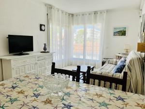 Sala de estar con mesa de comedor y TV en Apartamento Grecia 2 D, en L'Estartit