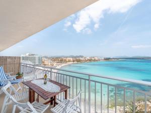 een balkon met een tafel en stoelen en de oceaan bij Apartamento rocamar in S'Illot