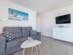 ein Wohnzimmer mit einem Sofa und einem Tisch in der Unterkunft Apartamento rocamar in S'Illot