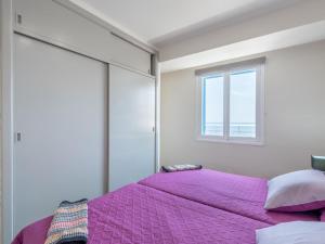 een slaapkamer met een paars bed en een raam bij Apartamento rocamar in S'Illot