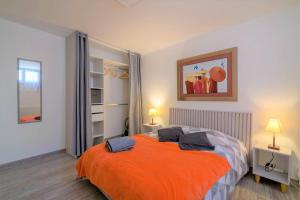 ein Schlafzimmer mit einem Bett mit einer orangefarbenen Decke in der Unterkunft Cosy House Near Paris 4 Bedrooms, Metro, Parking in Saint-Denis