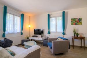 uma sala de estar com dois sofás e uma televisão em Cosy House Near Paris 4 Bedrooms, Metro, Parking em Saint-Denis