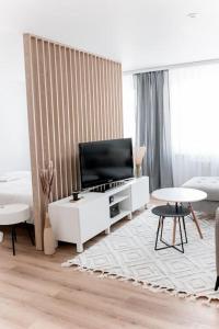 uma sala de estar com televisão num armário branco em Apartament Pastel Room em Leśna