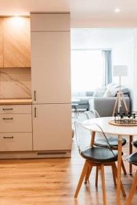 uma sala de estar com uma mesa e uma cozinha em Apartament Pastel Room em Leśna