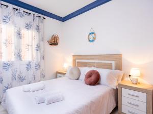 sypialnia z łóżkiem z białą pościelą i poduszkami w obiekcie Live Los Abrigos Agua Dulce w mieście Los Abrigos