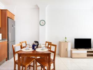 stół i krzesła w kuchni z zegarem na ścianie w obiekcie Live Los Abrigos Agua Dulce w mieście Los Abrigos