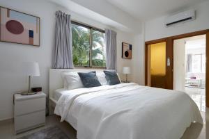 Un dormitorio blanco con una cama blanca y una ventana en Brand New Harmony Apartment with Pool and Gym in La Julia, en Santo Domingo