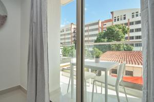d'un balcon avec une table et une vue sur la ville. dans l'établissement Brand New Harmony Apartment with Pool and Gym in La Julia, à Saint-Domingue