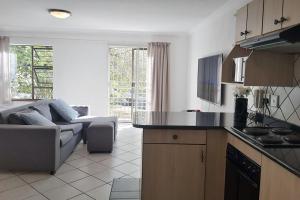 a kitchen and living room with a couch and a table at Spacious Hatfield Apartment in Pretoria