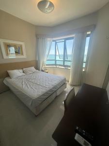 a bedroom with a bed and a view of the ocean at 952A golden fortaleza in Fortaleza