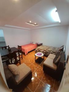 sala de estar con sofá y cama en Casa Apartamento Campestre en las Faldas del Tayta Imbabura, en San Juan de Ilumán
