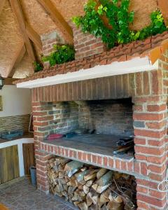 a brick oven with a stack of logs at La vita e bella in Maglenča