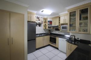 a kitchen with white cabinets and black appliances at Rondevoux 18 in Margate