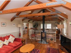 a living room with a red couch and a fireplace at Rosecott in St Ives
