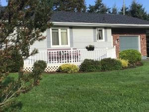 una casa con una valla blanca en un patio en Guest Suites at Willowgreen Farm, en Summerside