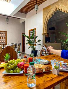 un tavolo in legno con bottiglie di cibo e acqua di Riad El Pacha a Rabat
