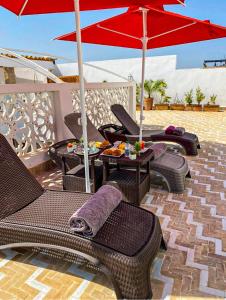 a patio with chairs and umbrellas on a patio at Riad El Pacha in Rabat