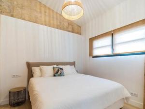 a bedroom with a large white bed and a window at Can montis in Palma de Mallorca