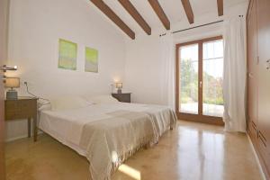 Un dormitorio blanco con una cama y una ventana. en Es Romegueral, en Artà 38 fotos más