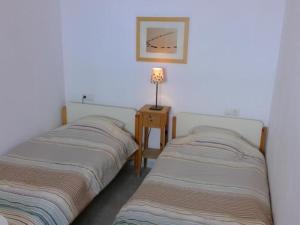 2 camas en una habitación con una lámpara en una mesa en Can Tassi, en Porto Cristo
