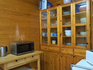 una cocina con armarios de madera y una mesa con microondas. en Can Tassi, en Porto Cristo