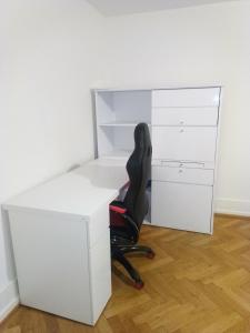 un bureau avec un bureau blanc et une chaise noire dans l'établissement Charming flat center and near the lake, à Genève