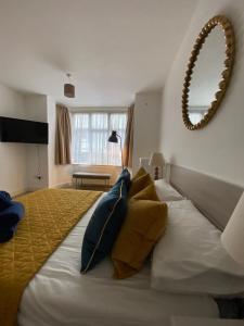 um quarto com uma cama grande com almofadas amarelas e azuis em The Queen’s apartments em Londres