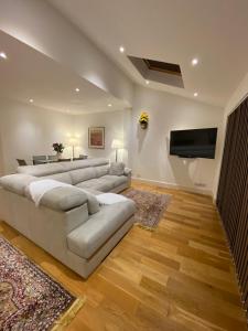 uma sala de estar com um sofá e uma televisão de ecrã plano em The Queen’s apartments em Londres