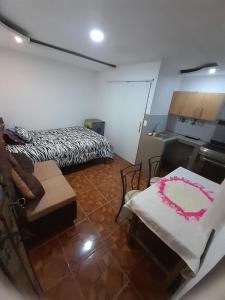 Zimmer mit einem Bett, einem Sofa und einem Tisch in der Unterkunft Casa campestre en las faldas del Taita Imbabura 3 in Otavalo
