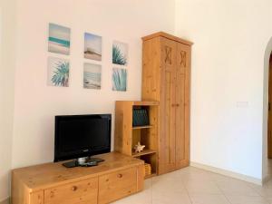 salon z telewizorem i drewnianą szafką w obiekcie Casa Dorotea w mieście Son Serra de Marina
