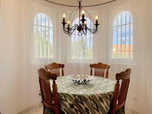 jadalnia ze stołem z krzesłami i żyrandolem w obiekcie Casa Dorotea w mieście Son Serra de Marina