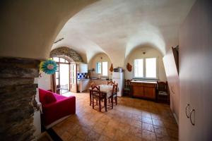 a kitchen and a living room with a red couch at Ginestra in Cipressa