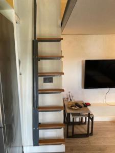 uma escada num quarto com uma mesa e uma televisão em Charming Castagnola em Lugano