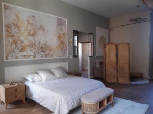 a bedroom with a bed and a painting on the wall at Gîtes à L'ABBAYE in Bournezeau +28 photos