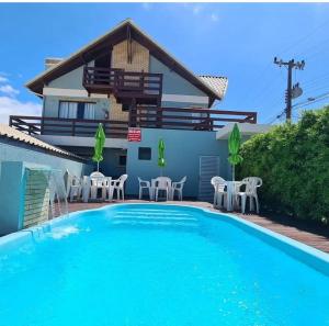 a villa with a swimming pool and a house at Residencial Las Dunas in Florianópolis