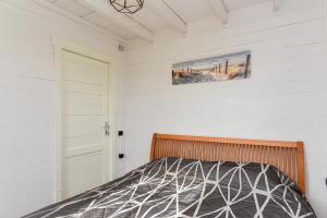 a bedroom with a bed and a door at Liepmalas - jaukus namukas Latvijos pajūryje in Nidden