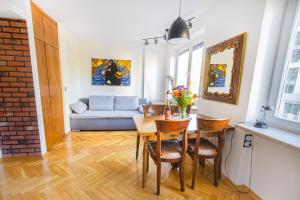 a living room with a table and chairs and a couch at Charming Apt next to Lazienki Park and City Center in Warsaw