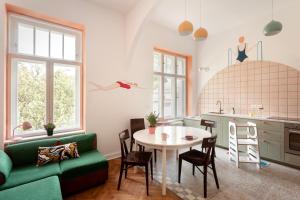 a kitchen and living room with a table and a green couch at Sopociaki in Sopot