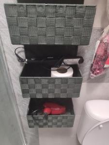 a bathroom with a toilet with two baskets next to it at Apartament confortabil in Chişinău