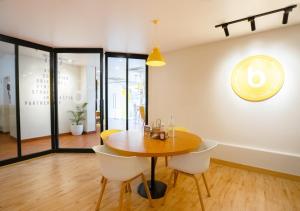 a dining room with a wooden table and white chairs at Bloom Hotel - HSR Layout Sec 6 in Bengaluru