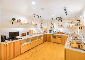 a large room with a kitchen with wooden cabinets at Bloom Hotel - HSR Layout Sec 6 in Bengaluru