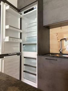 an empty refrigerator with its door open in a kitchen at Alpstern in Galtür