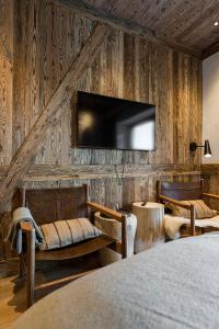 a bedroom with a tv on a wall with wood paneling at Nový pokoj Hotelu Emerich in Pec pod Sněžkou